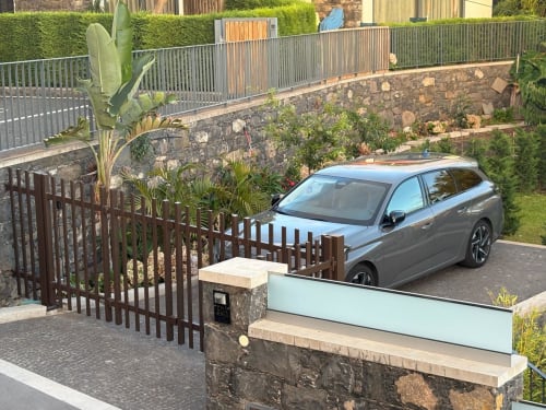 SUV cinzento estacionado na moradia de luxo BHF Residences em Arco da Calheta com muros de pedra e plantas tropicais