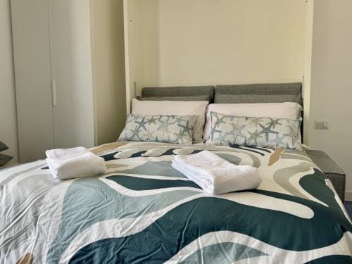 Letto moderno con coperta in tessuto decorato e cuscini a forma di stella marina presso Aurora View Resort, Italia