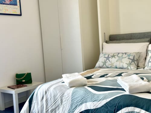 Camera Superior Aurora View Resort con biancheria a tema marino, cuscino a forma di stella marina, asciugamani bianchi e sedia verde al letto italiano