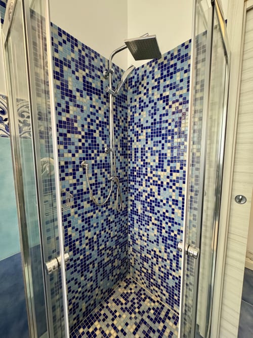 Elegante box doccia in mosaico blu moderno presso Aurora View Resort, camera d'hotel italiana con soffione pioggia