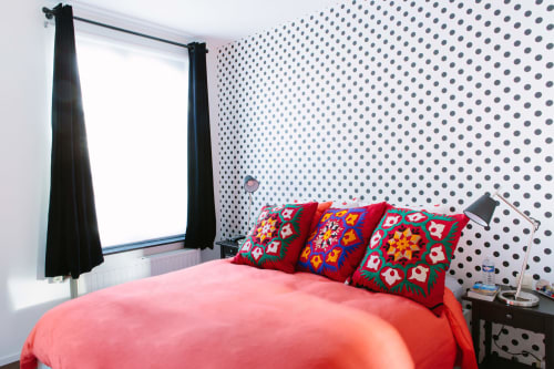 Chambre double lumineuse au B&B Place Jourdan Bruxelles avec parure de lit corail, coussins colorés, mur à pois et grande