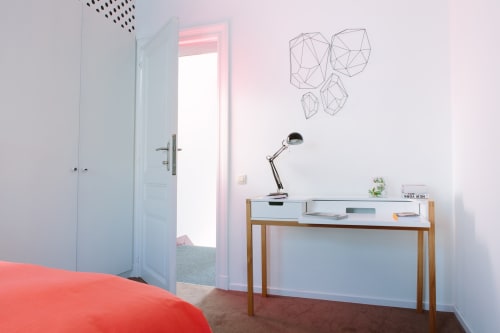 Chambre double moderne au B&B Place Jourdan à Bruxelles avec bureau, lampe de bureau et vue sur la ville par une baie vitrée encadrée de rose