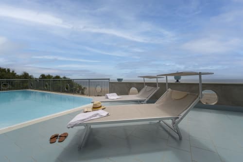 Lounge a bordo piscina dell'Aurora View Resort con lettini, struttura ombreggiata e panorami mozzafiato in Italia