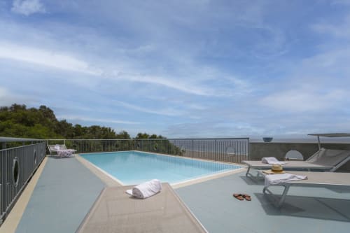 Piscina sulla terrazza dell'Aurora View Resort con lettini prendisole, vista panoramica e cielo azzurro in Italia