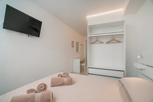 Camera moderna di Short Let's Olbia con letti gemelli, TV a schermo piatto, armadio e arredamento minimalista a Olbia