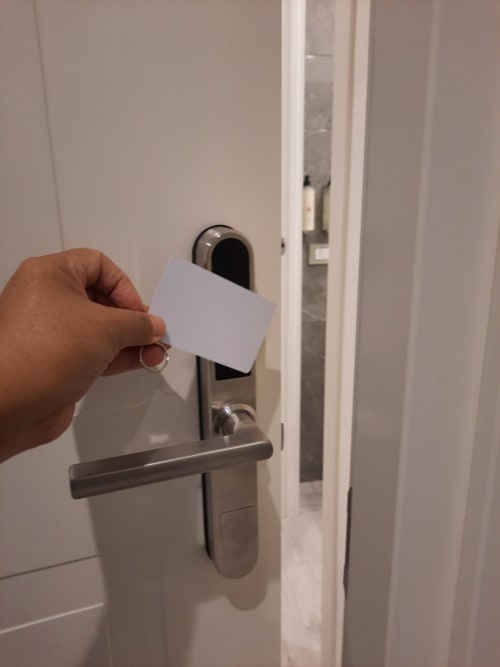Ospite con tessera magnetica alla serratura della porta nella camera Maritza Guest House Roma con moderna maniglia in acciaio