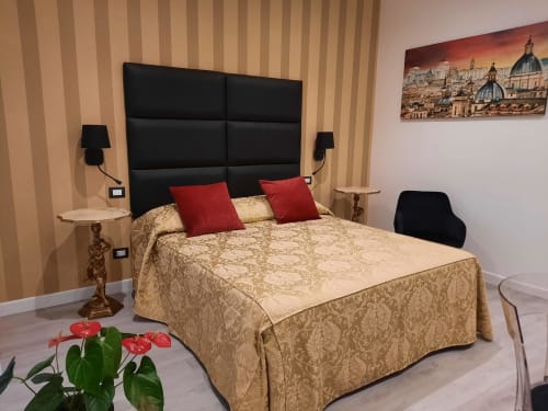 Camera elegante della Maritza Guest House a Roma con testata nera, biancheria damasco dorato, cuscini rossi e vista sulla città