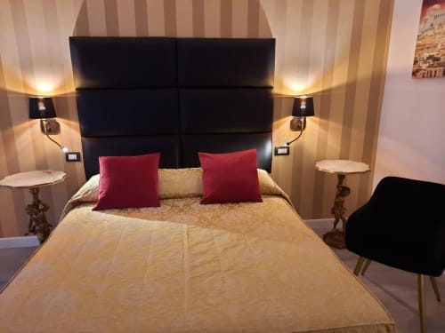 Camera Maritza Guest House Baldo a Roma con testata nera, cuscini rossi, biancheria dorata e illuminazione d'atmosfera