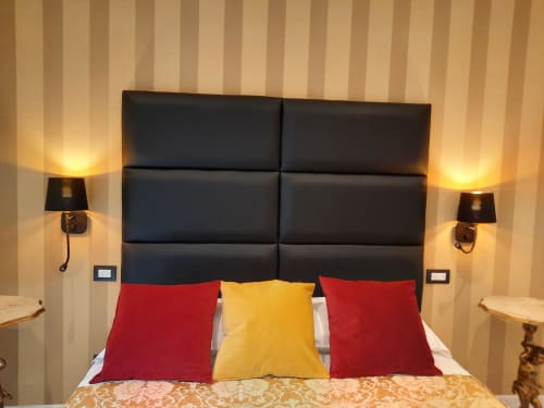 Camera moderna della Maritza Guest House Roma con testata imbottita nera, cuscini colorati e illuminazione calda