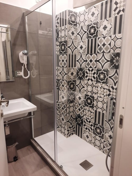 Bagno moderno di Maritza Guest House a Roma con piastrelle a motivi geometrici e doccia in vetro