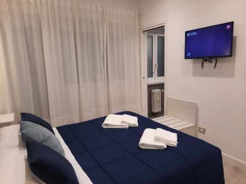 Camera Baldo con 3 letti presso Maritza Guest House Roma: letto matrimoniale, TV a schermo piatto e balcone con vista sulla città