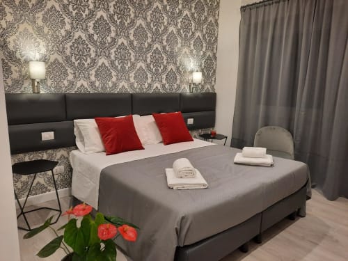 Camera Baldo 4 presso Maritza Guest House Roma: letto king, cuscini rossi, carta da parati damascata e vista sulla città