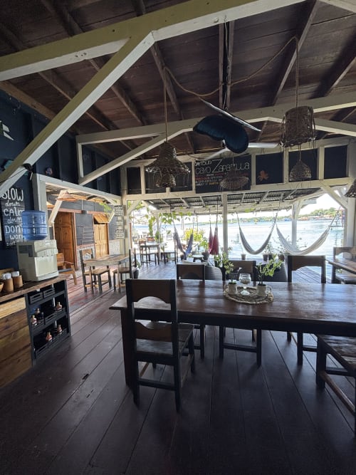 Open-air dining area with wooden tables, hammocks, and ocean views at BarrBra BnB in Bocas del Toro