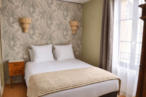 La chambre Willow d'Au Bon Séjour avec vue sur la ville, literie blanche, table de nuit en bois et papier peint motifs