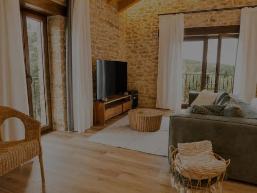 Habitación del Hotel Izarbe en Burgos con muros de piedra vista, mobiliario moderno y vistas a la montaña