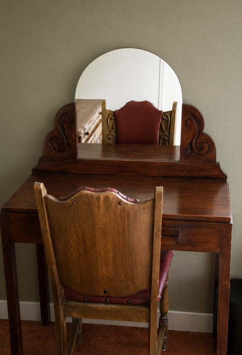 Wooden vanity with round mirror at Au Bon Séjour hotel in Sainte-Suzanne-et-Chammes