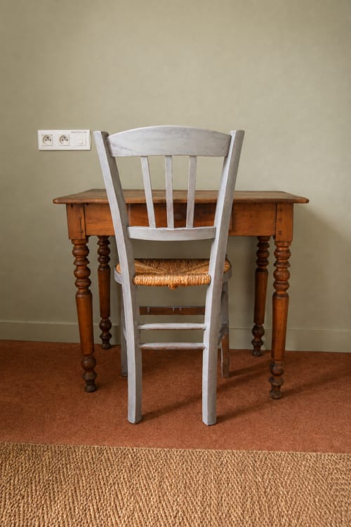 White bistro chair at wooden desk in Au Bon Séjour hotel room, Sainte-Suzanne-et-Chammes
