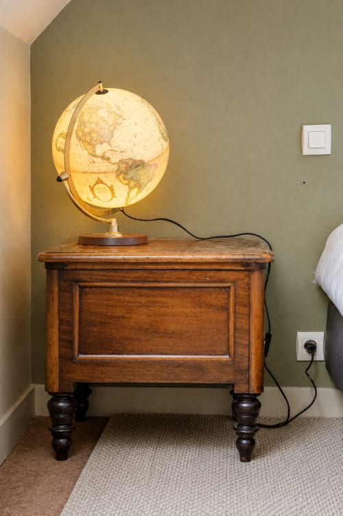 Illuminated globe lamp on wooden table in La Gavroche room at Au Bon Séjour hotel, Sainte-Suzanne-et-Chammes