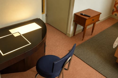 La Léonie hotel room at Au Bon Séjour with desk, side table, blue chair, and city views in Sainte-Suzanne-et-Chammes