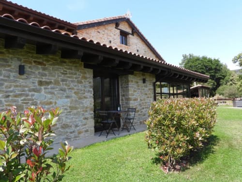 Casa rural Hotel Izarbe de piedra con jardines cuidados y terraza con asientos en Burgos, España