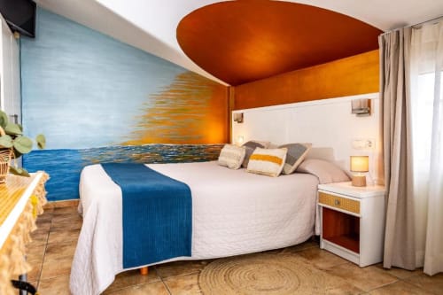 Habitación Doble Deluxe Moderna con cama curva, mural oceánico, diseño de techo naranja y pisos de baldosa terracota en Hotel La