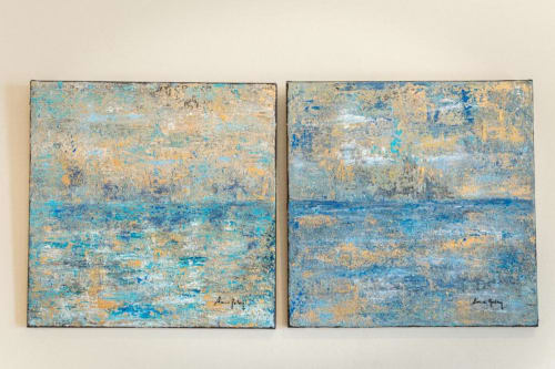 Par de cuadros abstractos inspirados en el océano con tonos azules y dorados en habitación del Hotel La Muntanya con vistas al mar