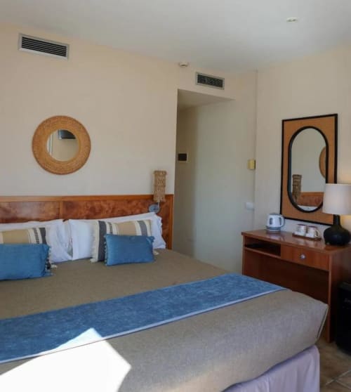 Habitación Doble Confort en Hotel La Muntanya de Llafranc con mobiliario de madera, detalles en azul y vistas al mar
