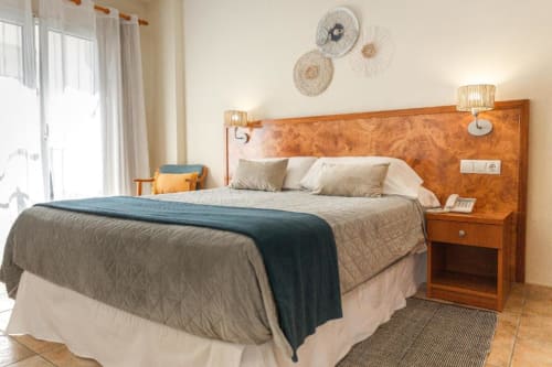 Habitación doble en Hotel La Muntanya en Llafranc con vista al mar, cabecero de madera y comodidades modernas