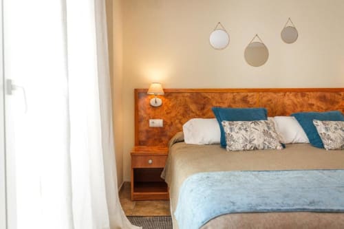 Habitación King-Size Premium del Hotel La Muntanya en Llafranc con cabecero de madera, detalles azules y espejos decorativos