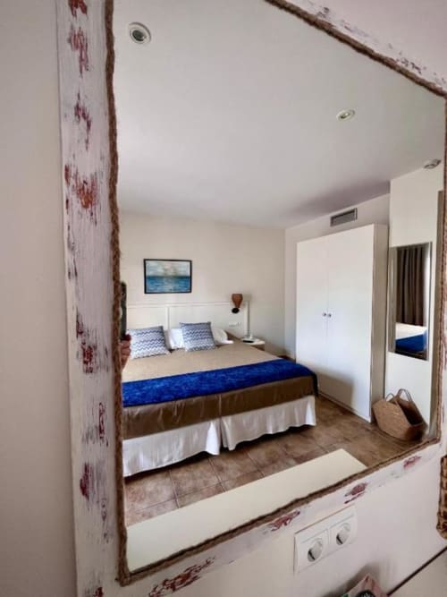 Habitación premium con cama king-size, ropa de cama azul y vistas a la ciudad en Hotel La Muntanya en Llafranc