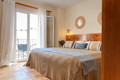 Habitación Doble de Confort con Balcón en Hotel La Muntanya en Llafranc con vistas al mar, cabecero de madera y balcón privado