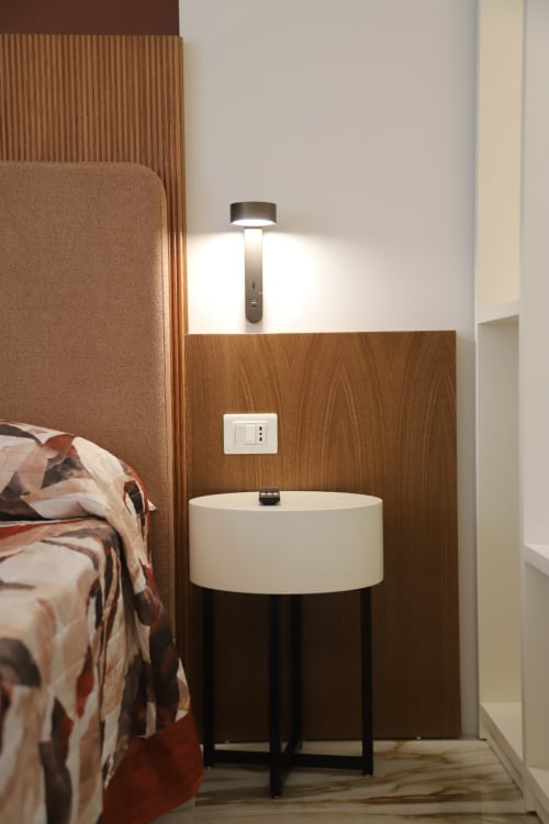 Moderno angolo camera da letto presso Totonno's Rooms Tropea con tavolino rotondo, rivestimento in legno e lampada a sospensione contemporanea