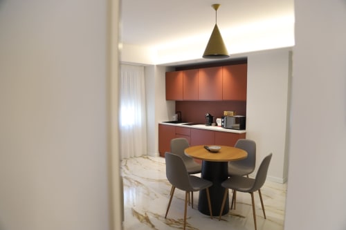Cucina e zona pranzo moderna presso Totonno's Rooms a Tropea con mobili rossi e tavolo rotondo