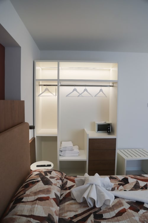 Camera moderna alle Totonno's Rooms di Tropea con armadio a muro, biancheria geometrica e vista sulla città