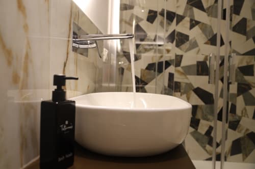 Moderno lavabo bianco con rubinetto cromato e dispenser di sapone nero nel bagno di Totonno's Rooms, Tropea