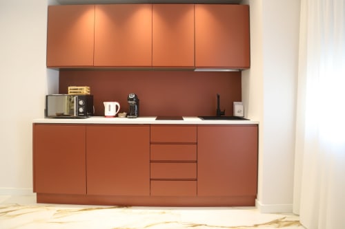 Cucina moderna con cabinetry arancione e piano di lavoro bianco nell'appartamento Totonno's Rooms a Tropea