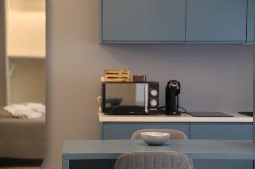 Moderna cucina con elettrodomestici e tavolo da pranzo con vista sulla città presso le Stanze di Totonno a Tropea