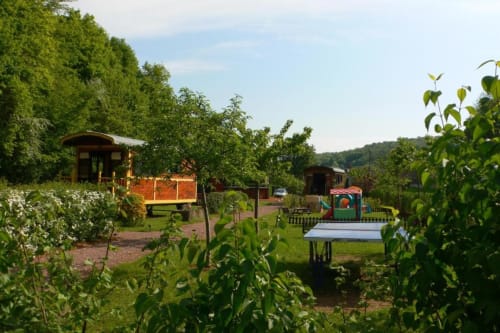 Roulottes tsiganes et structures de jardin au Relais de Maufront, un charmant gîte à Ouagne, France entouré de verdure