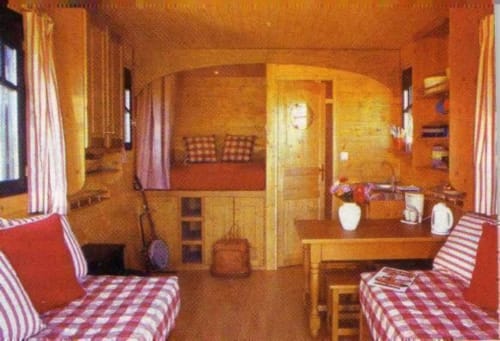 Chambre accueillante aux lits jumeaux du Gîte Le Relais de Maufront à Ouagne avec parure rouge à carreaux et boiseries chaleureuses