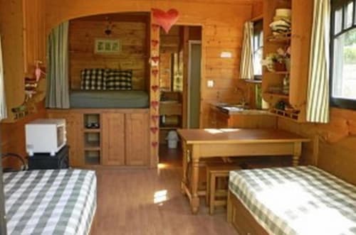 Chambre chaleureuse au Relais de Maufront : lits jumeaux, literie rayée et mobilier rustique en sapin à Ouagne