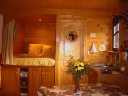 Chambre cosy avec lit intégré, fleurs et lumière chaleureuse au Relais de Maufront à Ouagne