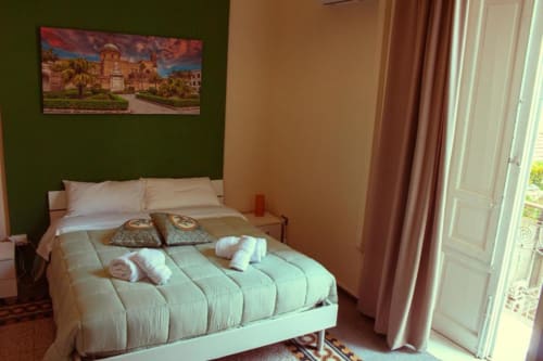 Camera Tripla presso Mizzica Rooms a Palermo con biancheria menta, balcone, vista sulla città e comfort moderni