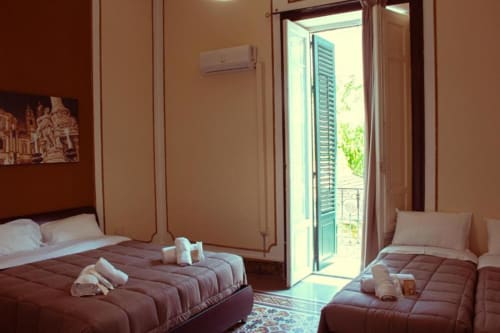 Camera Quadrupla a Mizzica Rooms a Palermo con letti gemelli, aria condizionata, balcone con vista sulla città e servizi moderni