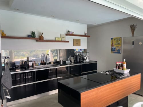 Cuisine moderne avec meubles noirs, îlot en bois et appareils inox à la villa Résidence Thalie en Martinique