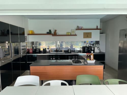Cuisine moderne avec armoires noires, îlot en bois, électroménagers en acier inoxydable et vue sur mer à la villa Résidence Thalie