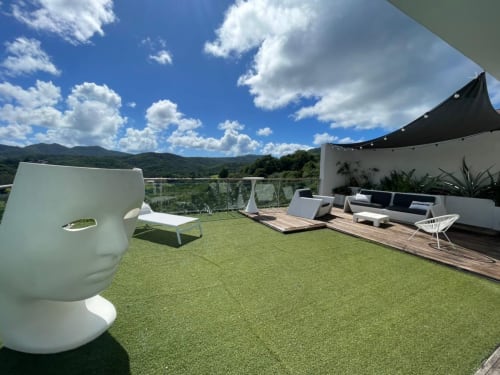 Terrasse moderne de la villa Résidence Thalie avec vue mer, sculpture tête blanche, salon de détente et montagnes