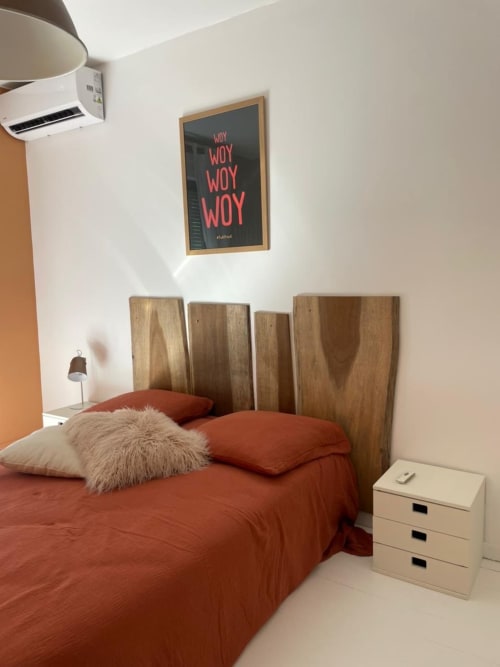 Chambre moderne de la villa Les Trois-Îlets avec parure terracotta, tête de lit en bois et décoration murale inspirante