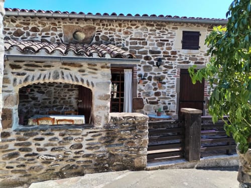 Rustic stone cottage with arched fireplace and wooden gate, Cévennes gîte in Gagnières, France