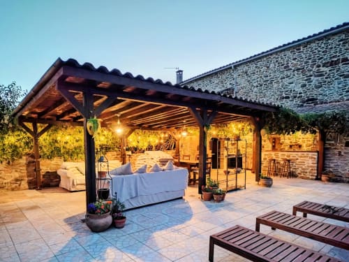 Evening patio with pergola, lounge seating, and stone cottage at Mes Maisons pet-friendly gîte in Cévennes, France