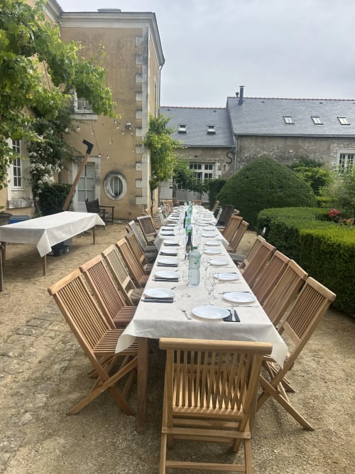 Grande table de réception dressée en plein air dans le jardin de la Cour Du Liège à Baugé-en-Anjou